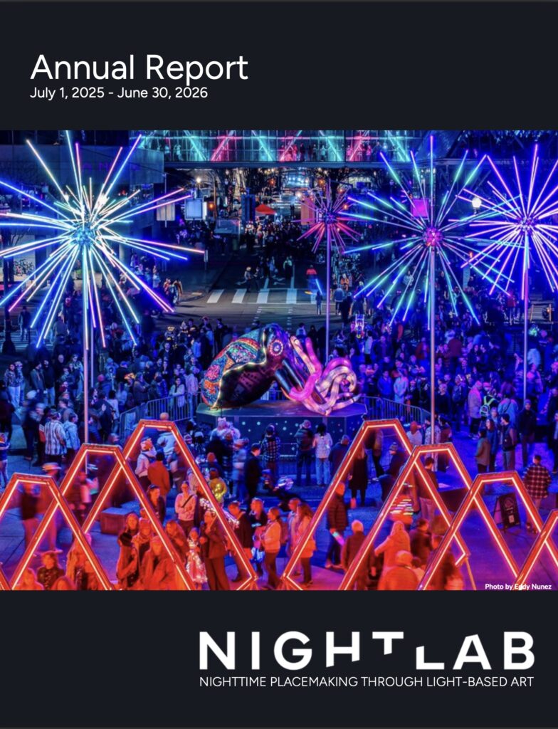 cover of annual report downtown at night illuminated by several glowing large art installations